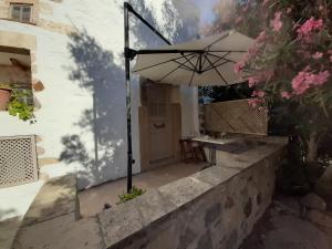 a patio with an umbrella and a table at En Patmo Holiday Home in Patmos