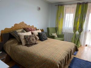 ein Schlafzimmer mit einem großen Bett mit Kissen in der Unterkunft CASA DE SUB MAGURA in Simeria