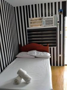 Una cama con dos toallas en una habitación en DJCI Apartelle Small Rooms, en Cabanatúan