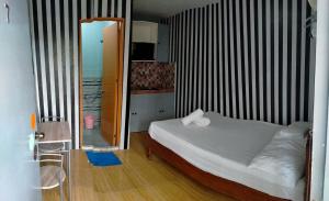 a small bedroom with a bed and a mirror at DJCI Apartelle Walk to Robinson & NE Pacific Mall 3 Min to SM Cabanatuan in Cabanatuan