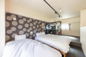 two beds in a room with polka dots on the wall at VACATION INN KAMATA I in Tokyo +53 photos