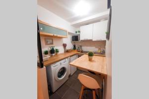 uma cozinha com uma máquina de lavar roupa e uma máquina de lavar roupa em Le Confortable-Cosy studio à 3 minutes du métro em Pantin
