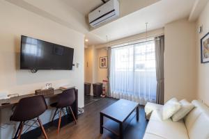 a living room with a couch and a table and a tv at VACATION INN KAMATA I in Tokyo