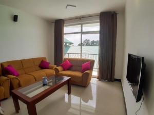 uma sala de estar com um sofá e uma mesa em Flamingo's Nuwara Eliya em Nuwara Eliya