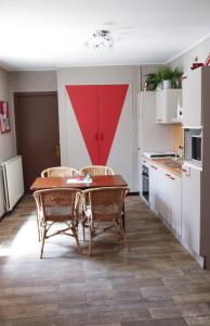 eine Küche mit einem Tisch und Stühlen im Zimmer in der Unterkunft Gîte De La Souris Verte in Molamboz
