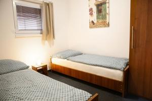 2 camas individuales en una habitación con ventana en Penzion Tyra en Třinec