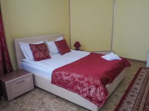 イヴァノヴォにあるOrion Innのベッドルーム(白いベッド、赤い枕付)