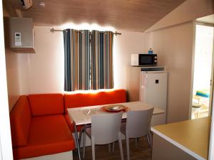 a living room with an orange couch and a table at Mobile home Happy days in Sveti Juraj