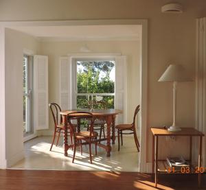 uma sala de jantar com uma mesa e cadeiras e uma janela em Klaasvoogds Cottages em Robertson
