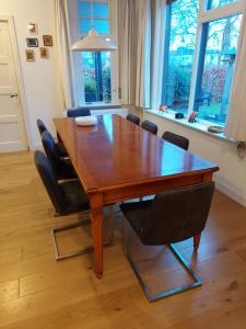 mesa de comedor de madera con sillas negras y mesa en huisje Nieuw Vliet, en Nieuwvliet