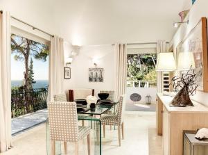 a kitchen and dining room with a glass table and chairs at Villa Marina Little Beach in Capri