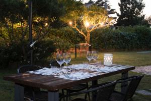 a wooden table with wine glasses on top of it at Mami Sabaudia Hotel in Sabaudia