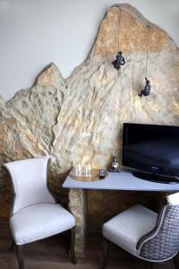 Ein Zimmer mit einem Tisch, einem Fernseher und zwei Stühlen in der Unterkunft Hotel Wandersleben - Erfurt in Wandersleben