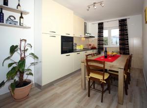 a kitchen with a wooden table and a dining room at Apartment Milenka in Čilipi