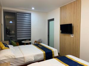 a hotel room with two beds and a flat screen tv at VISION HOTEL in Phan Rang–Tháp Chàm