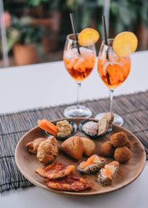 a plate of food and two glasses of wine at Mami Sabaudia Hotel in Sabaudia