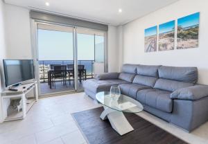 een woonkamer met een bank en een glazen tafel bij 024 - Blue Dreams Penthouse Tabarca - comfortHOLIDAYS in Arenales del Sol