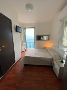 una camera con letto e vista sull'oceano di Sollevante Guest House a Riomaggiore