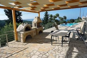 a patio with a table and an outdoor oven at Kukuwaia in Almyrida
