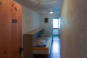 ダボスにあるRichmond Davos - Suite 207の小さな客室で、廊下に小さなベッドが備わります。