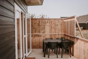a patio with a table and chairs on a fence at ZTLND Familylodge in Zoutelande