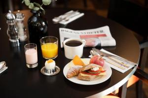 a table with a plate of breakfast food and a newspaper at ProfilHotels Nacka in Stockholm