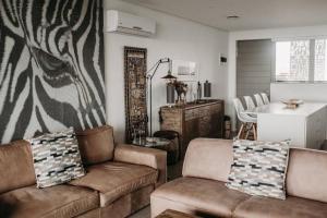 ein Wohnzimmer mit einem Sofa und einem Zebra-Wandbild in der Unterkunft Luxury Apartment near the Airport with Sea View in Umhlanga