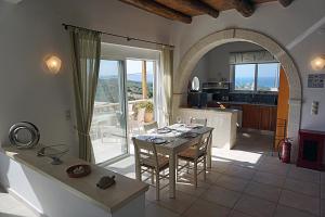 a living room with a table and a kitchen with a view at Kukuwaia in Almyrida