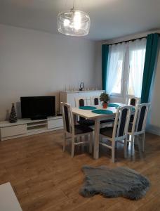 uma sala de jantar com uma mesa e cadeiras e uma televisão em Apartament Góra Szybowcowa em Jelenia Góra