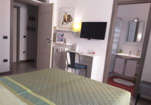 ナポリにあるB&B Carolina Napoli-Vomeroのベッドルーム(ベッド1台、デスク、テレビ付)