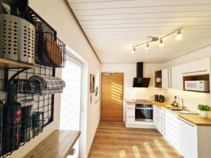 een keuken met witte kasten en een houten vloer bij Ferienwohnungen Sommer in Bayerisch Gmain