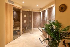a bathroom with a shower and a plant at Hotel Belvedere in Warnemünde