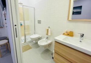 a white bathroom with a toilet and a sink at The Dream in Massa Lubrense