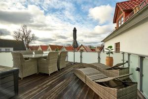 a balcony with chairs and a table on a building at Hotel Belvedere in Warnemünde