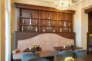 a restaurant with two tables and chairs and a shelf of vases at Hotel Belvedere in Warnemünde