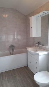 a bathroom with a white tub and a sink and a toilet at Apartments Lumbarda in Lumbarda