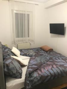 a bedroom with two beds and a flat screen tv at Apartman SLAVONIA 3 in Ðakovo