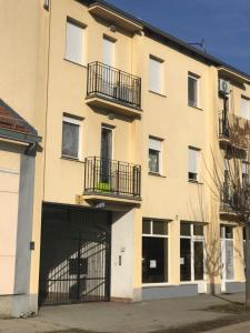 an apartment building with two balconies and a garage at Apartman SLAVONIA 3 in Đakovo