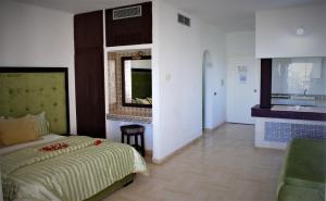 a bedroom with a bed and a mirror on the wall at Residence Ain Meriem in Bizerte