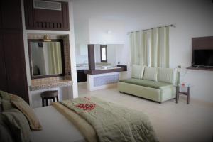 a bedroom with a bed and a chair and a mirror at Residence Ain Meriem in Bizerte +27 photos