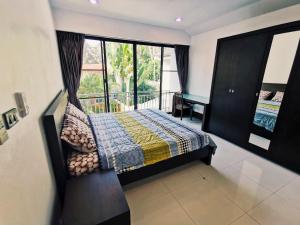 a bedroom with a bed and a balcony at 4poolvillas in North Pattaya