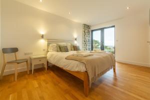 Un dormitorio con una cama grande y una ventana grande en Teyr Mor Cliff, en St. Agnes