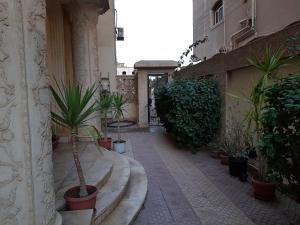 a courtyard with potted plants on the side of a building at Elite Homes 3BR Garden Apartment Families Only in 6th Of October