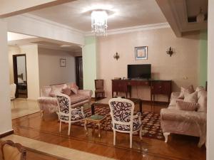 sala de estar con sofá, mesa y sillas en Elite Homes 3BR Garden Apartment Families Only en 6th Of October