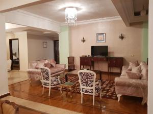 a living room with a couch and a table and chairs at Elite Homes 3BR Garden Apartment Families Only in 6th Of October