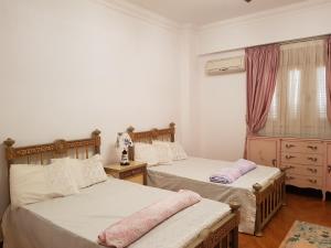 1 dormitorio con 2 camas y ventana en Elite Homes 3BR Garden Apartment Families Only en 6th Of October