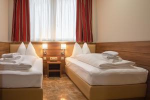 a hotel room with two beds and a window at Work & Sleep Boardinghouse Mannheim in Mannheim