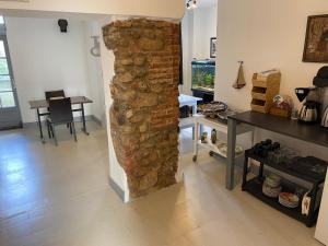 a stone pillar in a room with a table and a dining room at Auberge du Chêne in Maureillas