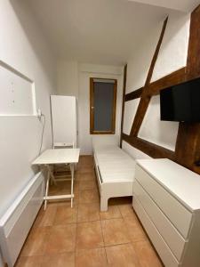 ein kleines Zimmer mit weißen Möbeln und einem Fenster in der Unterkunft Apartment nahe Unikliniken in Erlangen