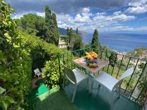 a table and chairs on a balcony with a view of the ocean at Villa Don Mimì Guarnaschelli la dependace in Taormina